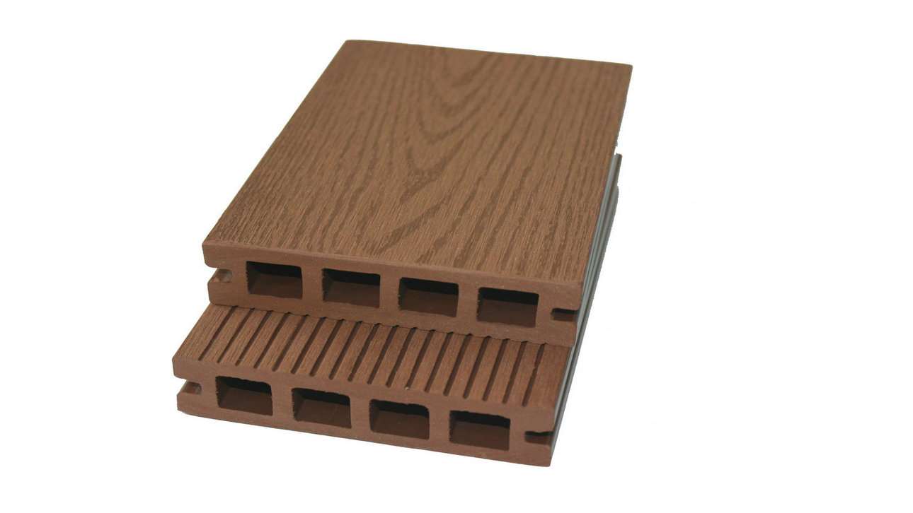 Overhead flat-lay photograph of two stacked brown wood-grain composite decking boards, one grooved and one smooth, arranged diagonally on a soft white surface, warm natural light, earthy tan and dark walnut tones with a calm, tactile mood.