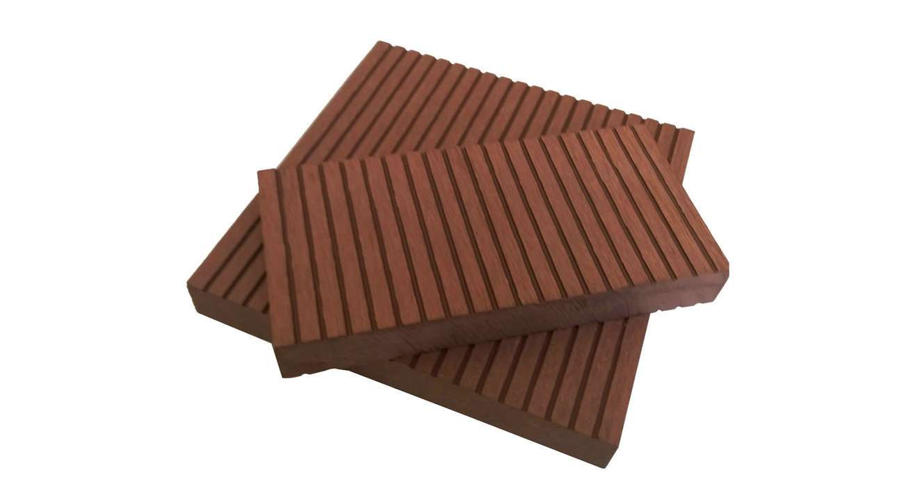 Overhead flat-lay of two reddish-brown grooved deck boards laid crosswise on a white surface