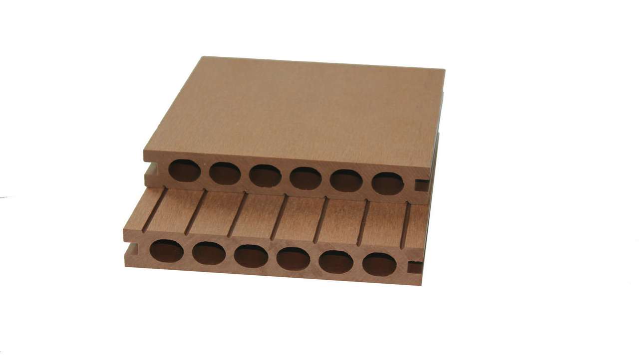 Overhead flat-lay photograph of two stacked brown composite decking boards on a white background, one with a smooth top and one with ribbed grooves, showing hollow round-holed cross-section in warm earthy brown tones