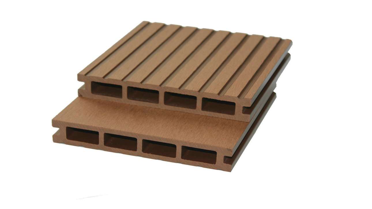 Overhead flat-lay photograph of two stacked tan composite decking boards, one with deep ribbed grooves and one smooth, hollow chambers visible, on white background, bright even light, warm honey and toasted oak tones with a neutral product-study mood.